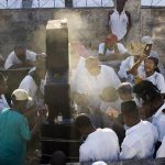 Haitians gather at a tombstone on All Saints Day